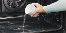 Persona vertiendo agua en la cavidad del horno
