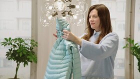 Mujer admirando su cazadora de plumas recién lavada